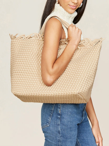 A woman carrying a Naghedi Havana Beach Tote in Solid Camel Fringe on her shoulder.