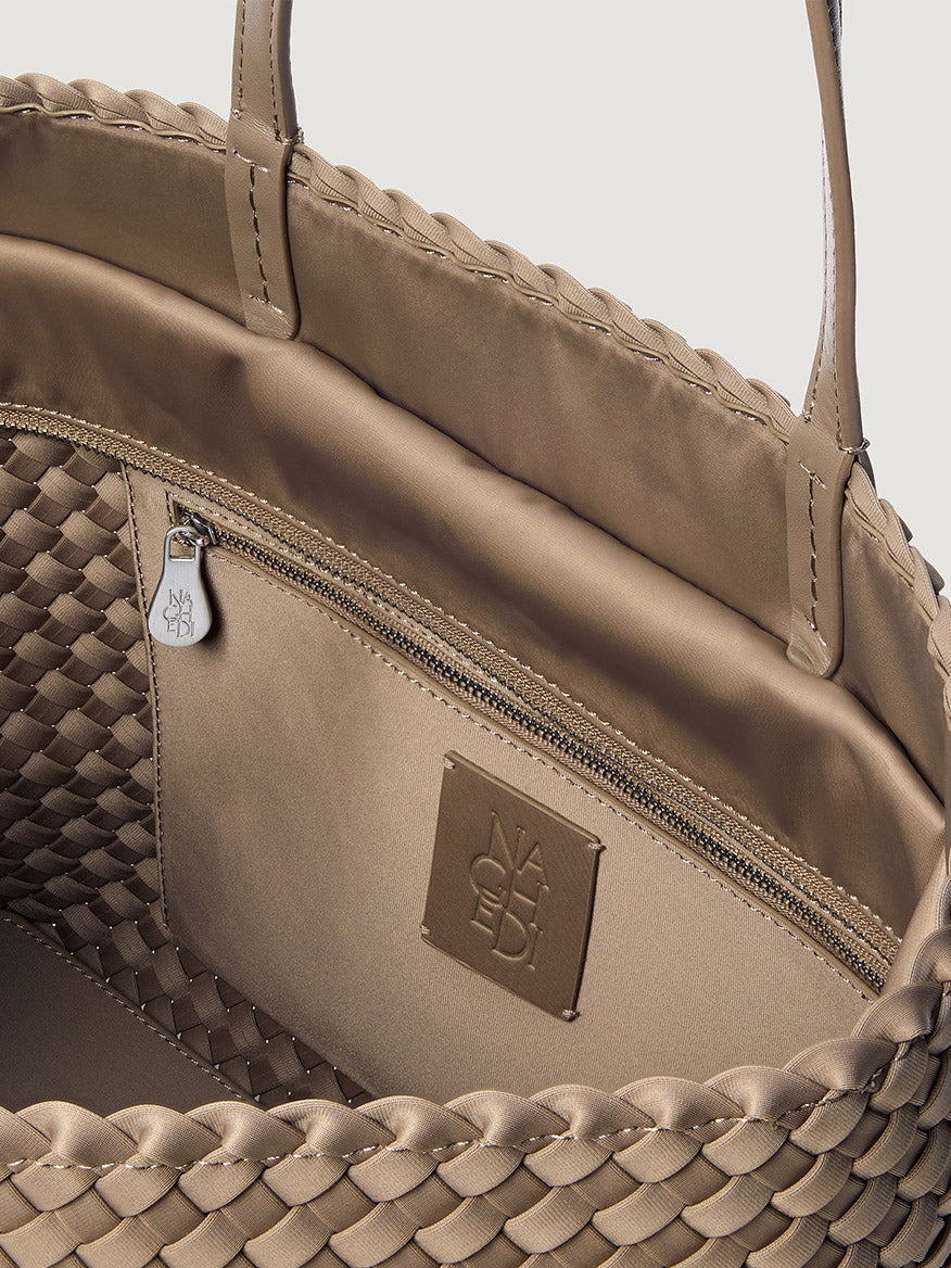 Interior view of a cashmere Naghedi Jetsetter Small Tote, featuring a zippered pocket with a branded pull and a rectangular logo patch.