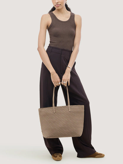 A person holding a beige Naghedi Jetsetter Small Tote in Cashmere.