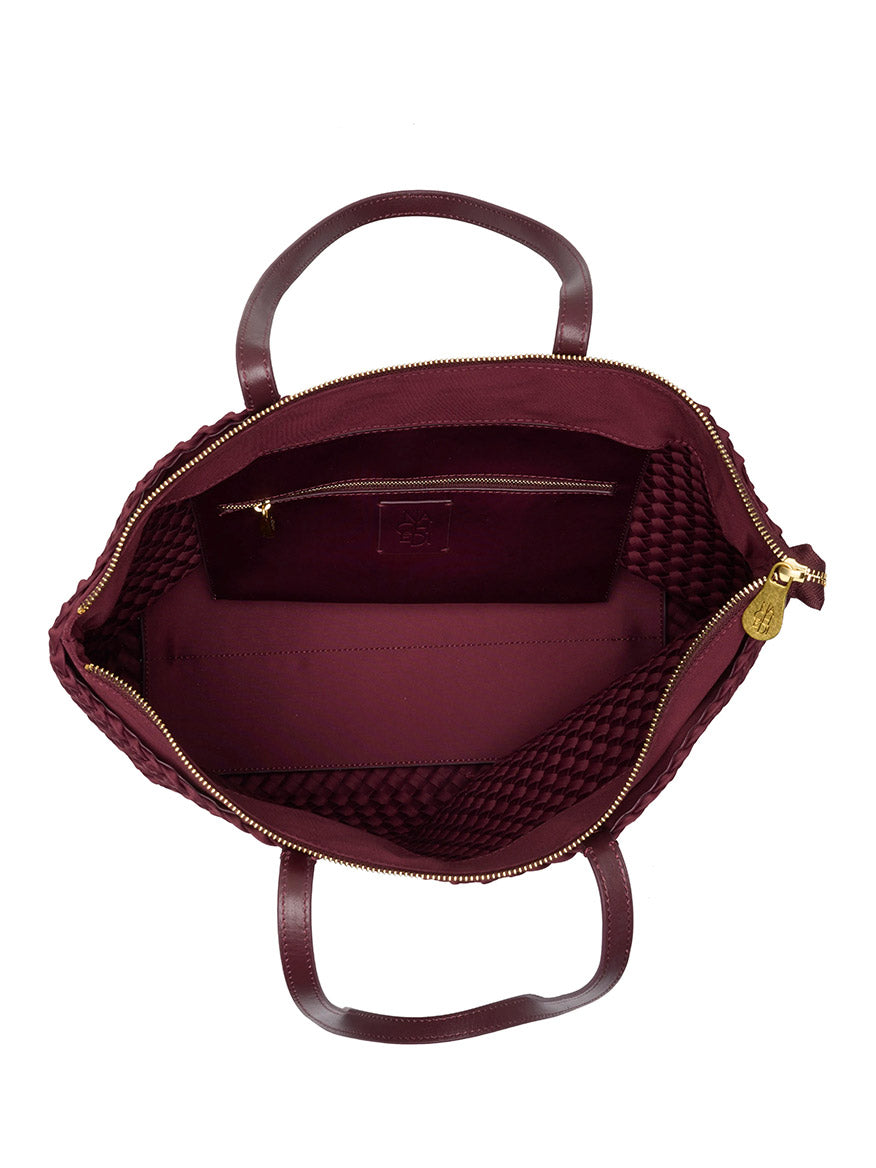Top-down view of an open, dark red Naghedi Jetsetter Small Tote in Bordeaux with a zippered main compartment and an interior pocket.