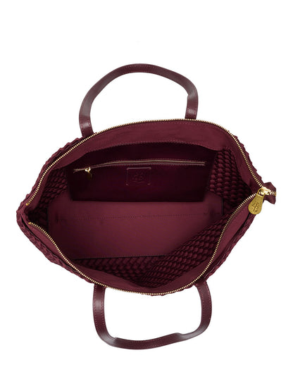 Top-down view of an open, dark red Naghedi Jetsetter Small Tote in Bordeaux with a zippered main compartment and an interior pocket.