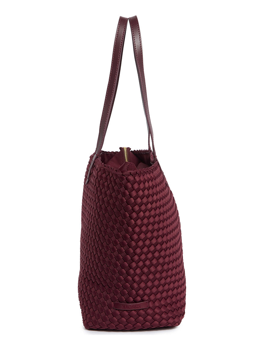 Side view of a dark red Naghedi Jetsetter Small Tote with shoulder straps and a top zipper.