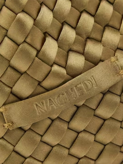 Close-up of a Naghedi Kyoto Clutch Satin in Peridot, featuring a woven textile and an embossed brand label.