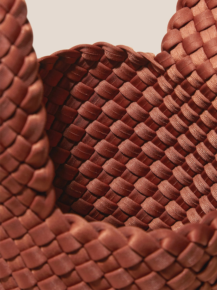 Close-up of a Naghedi Kyoto Clutch in Solid Adobe handwoven neoprene texture.