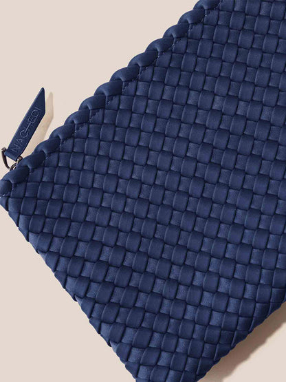 A close-up of the roomy and comfortable Solid Ink Blue woven pouch against a light background, showcasing its prominent zipper pull. Made from handwoven neoprene, this versatile accessory complements the Naghedi Nomad Hobo lifestyle perfectly.