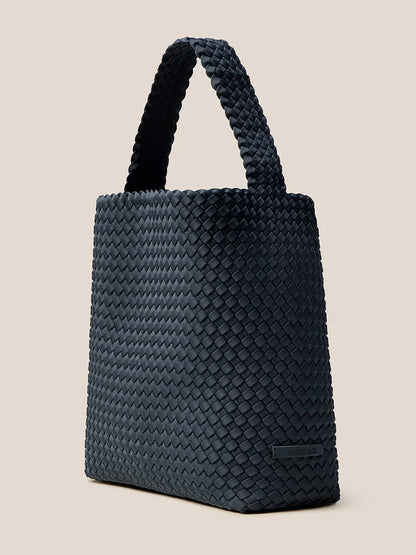 A Naghedi Nomad Hobo in Solid Murano, featuring a sturdy handle and a sleek handwoven neoprene finish on a light background.