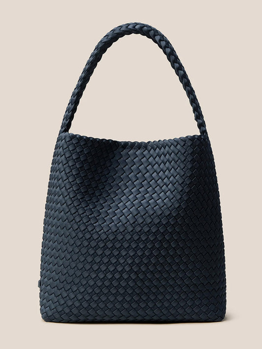 The Naghedi Nomad Hobo in Solid Murano, a black handwoven neoprene handbag featuring a single looped handle, is elegantly displayed against a plain beige background.