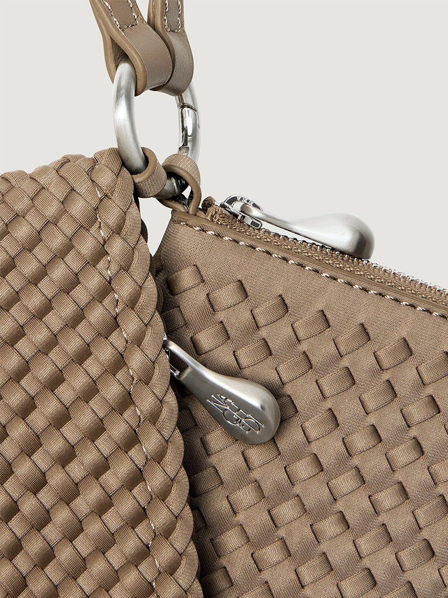 Naghedi Orly Phone Case in Cashmere, a tan woven crossbody pouch with a silver zipper closure and a matching detachable strap.