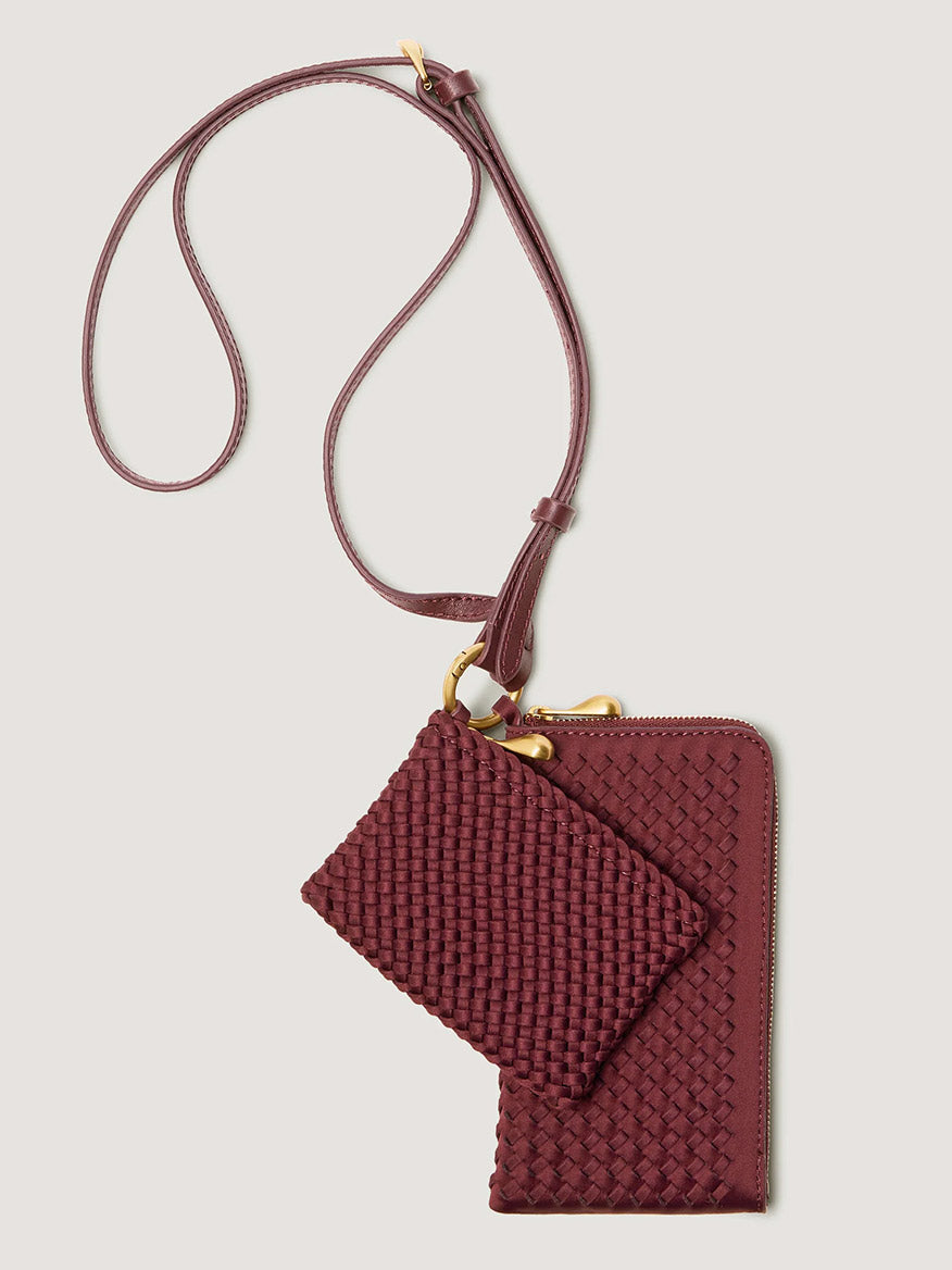 Naghedi Orly Phone Case in Bordeaux: a deep red woven crossbody phone pouch with an attached matching coin purse, adjustable leather strap, and gold-toned hardware.