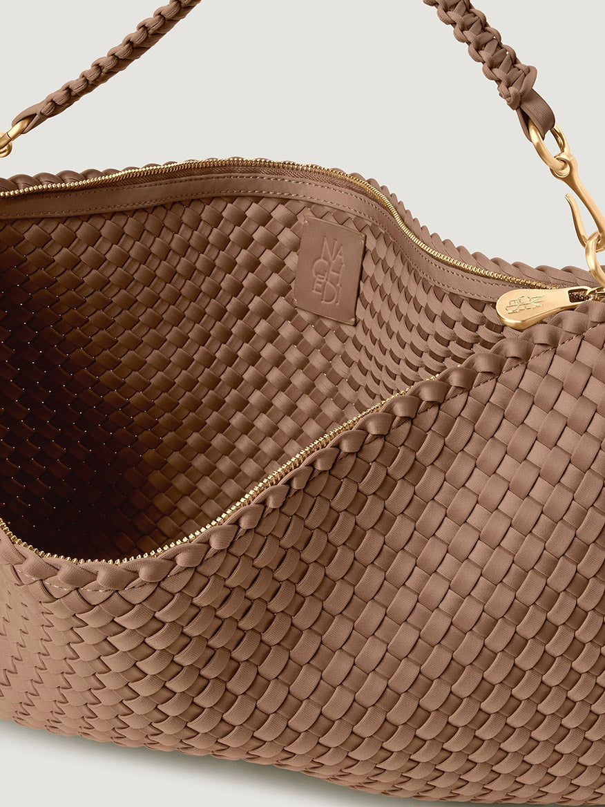 Naghedi Porto Medium Half-Moon Bag in Seychelles, a tan, woven neoprene shoulder bag featuring a zipper closure and a braided strap.