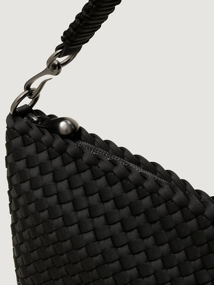 Close-up of the Naghedi Porto Small Half-Moon Bag in Onyx, a black handwoven neoprene bag with a zipper closure and a black metal clasp on the handle.