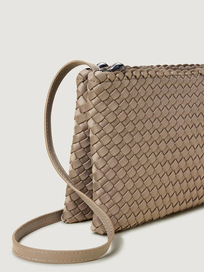 Close-up of the Naghedi Soho Envelope Crossbody in Cashmere, featuring a beige woven neoprene design and adjustable leather strap, shown against a plain light background.