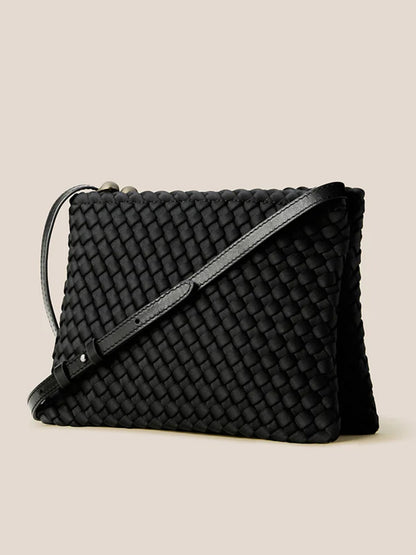 The Naghedi Soho Envelope Crossbody in Onyx features woven leather and a long, adjustable strap, shown against a plain beige background.