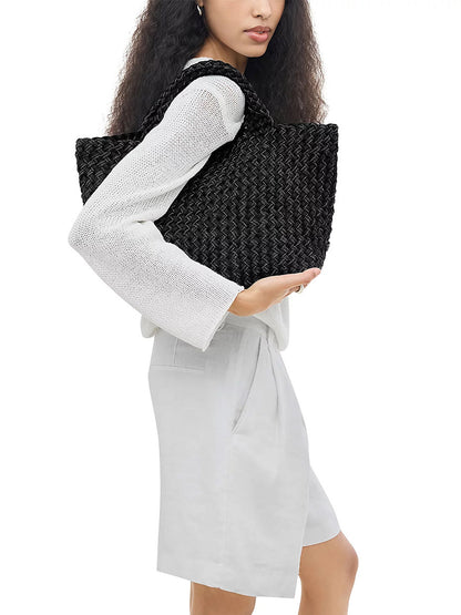 Person carrying a jet Naghedi St. Barths Medium Double Weave Tote under their arm.