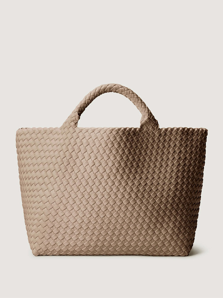 Naghedi St. Barths Medium Tote in Cashmere, a beige handwoven bag with a woven exterior and two braided top handles.