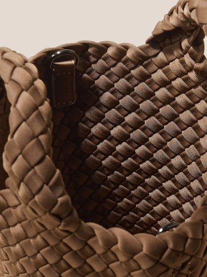 Close-up view of an open Naghedi St. Barths Petit Tote in Solid Mink, showcasing the intricate basket weave pattern and crossbody strap.