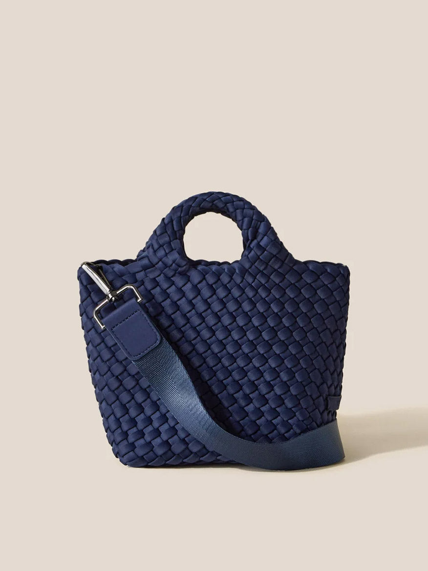 A Naghedi St. Barths Petit Tote in Solid Ink Blue with a matching shoulder strap displayed against a light beige background.