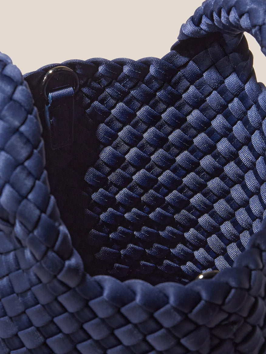 Close-up of a blue Naghedi St. Barths Petit Tote in Solid Ink Blue with intricate handwoven neoprene texture and visible interior dark lining.