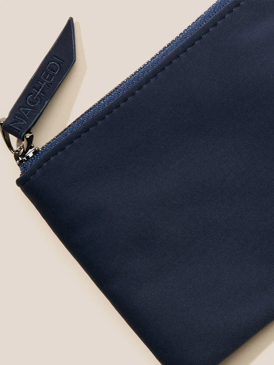 Navy blue Naghedi St. Barths Petit Tote in Solid Ink Blue with a branded zipper pull and a crossbody strap on a light background.