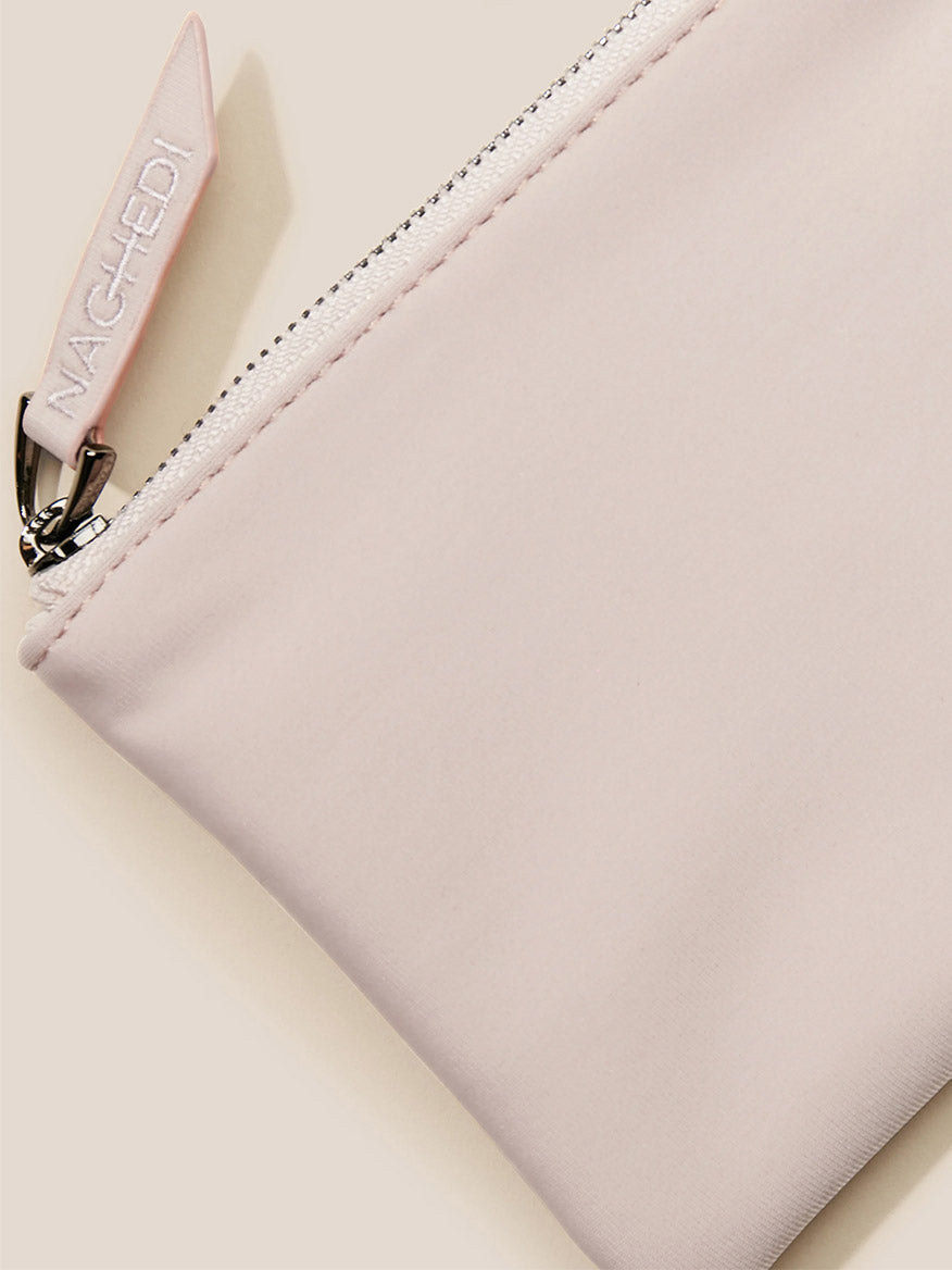 Close-up of a Naghedi St. Barths Petit Tote in Solid Shell Pink with a zipper and branded pull-tab.