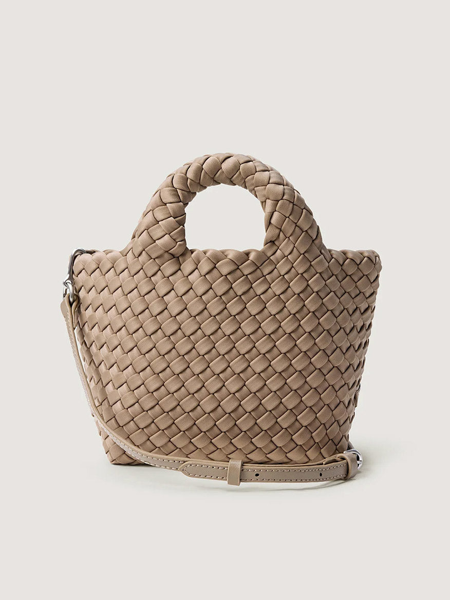 Naghedi St. Barths Petit Tote in Cashmere: a beige handwoven neoprene mini tote bag with two top handles and a detachable crossbody strap.