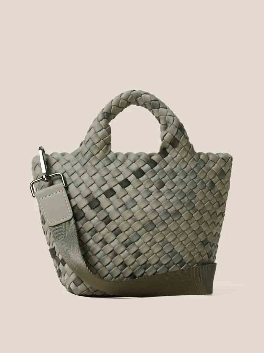 The Naghedi St. Barths Petit Tote in Watercolor Neptune is a green handwoven neoprene handbag that includes a detachable crossbody strap and two sturdy handles, set against a plain background.