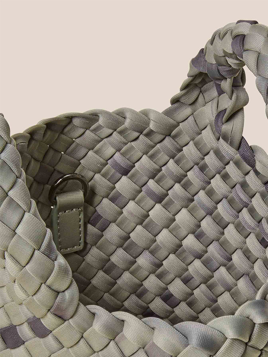 Close-up of a Naghedi St. Barths Petit Tote in Watercolor Neptune, showcasing its checkered pattern in shades of green and gray. This basket-style design features a handle made from handwoven neoprene, combining durability with style.