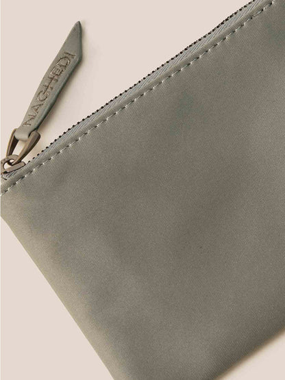 A zippered gray pouch with a textured surface, showcasing the brand name on the zipper pull, complements your Naghedi St. Barths Petit Tote in Watercolor Neptune beautifully.