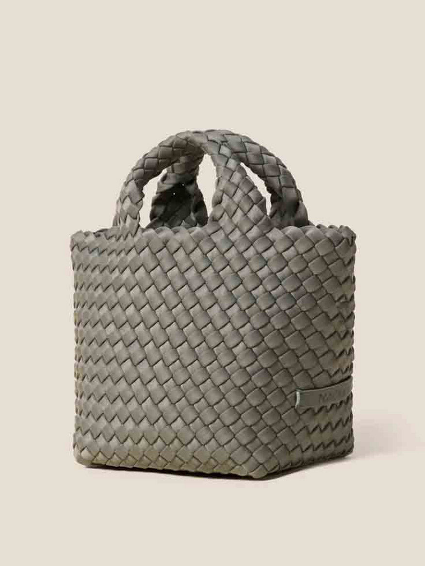 Against a plain background stands a gray, handwoven neoprene basket with handles, echoing the sophisticated design of the Naghedi St. Barths Petit Tote in Solid Laurel.