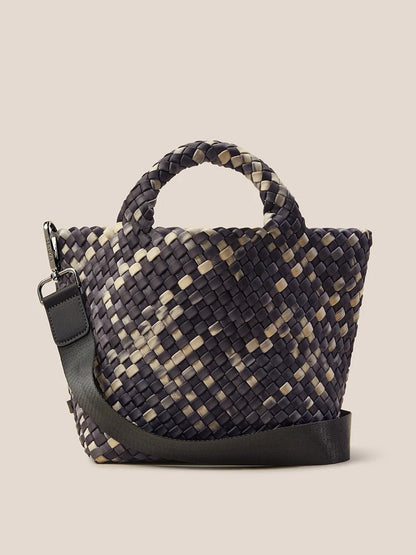 The Naghedi St. Barths Small Tote in Watercolor Nimbus is a woven handbag with a checkered pattern in dark gray and beige. It features a short handle, a detachable crossbody strap, and is crafted from handwoven neoprene, making it perfect for versatile style on the go.