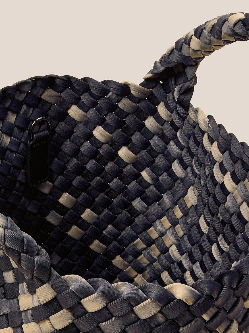 Close-up of a Naghedi St. Barths Small Tote in Watercolor Nimbus, featuring a handwoven neoprene design with a black and beige checkered pattern and a handle on one side.