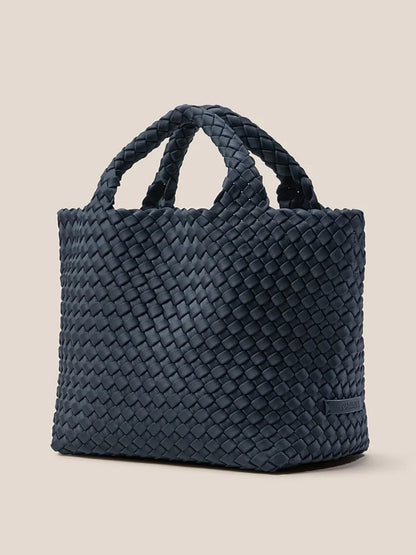 Naghedi St. Barths Small Tote in Solid Murano, a handwoven neoprene bag with short handles, showcased against a plain beige background.