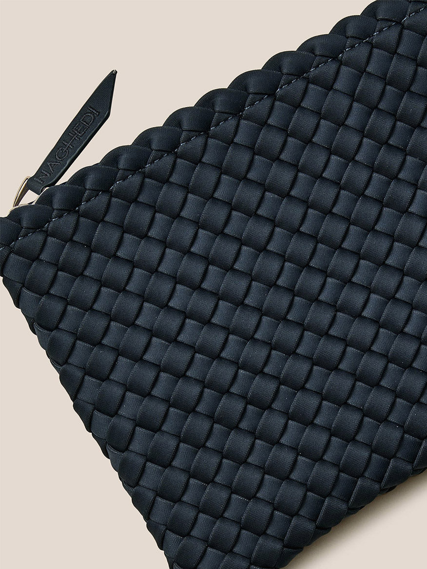 The Naghedi St. Barths Small Tote in Solid Murano is ideal for slipping this black, handwoven neoprene pouch into it or attaching a crossbody strap, featuring a visible zipper pull for added convenience.