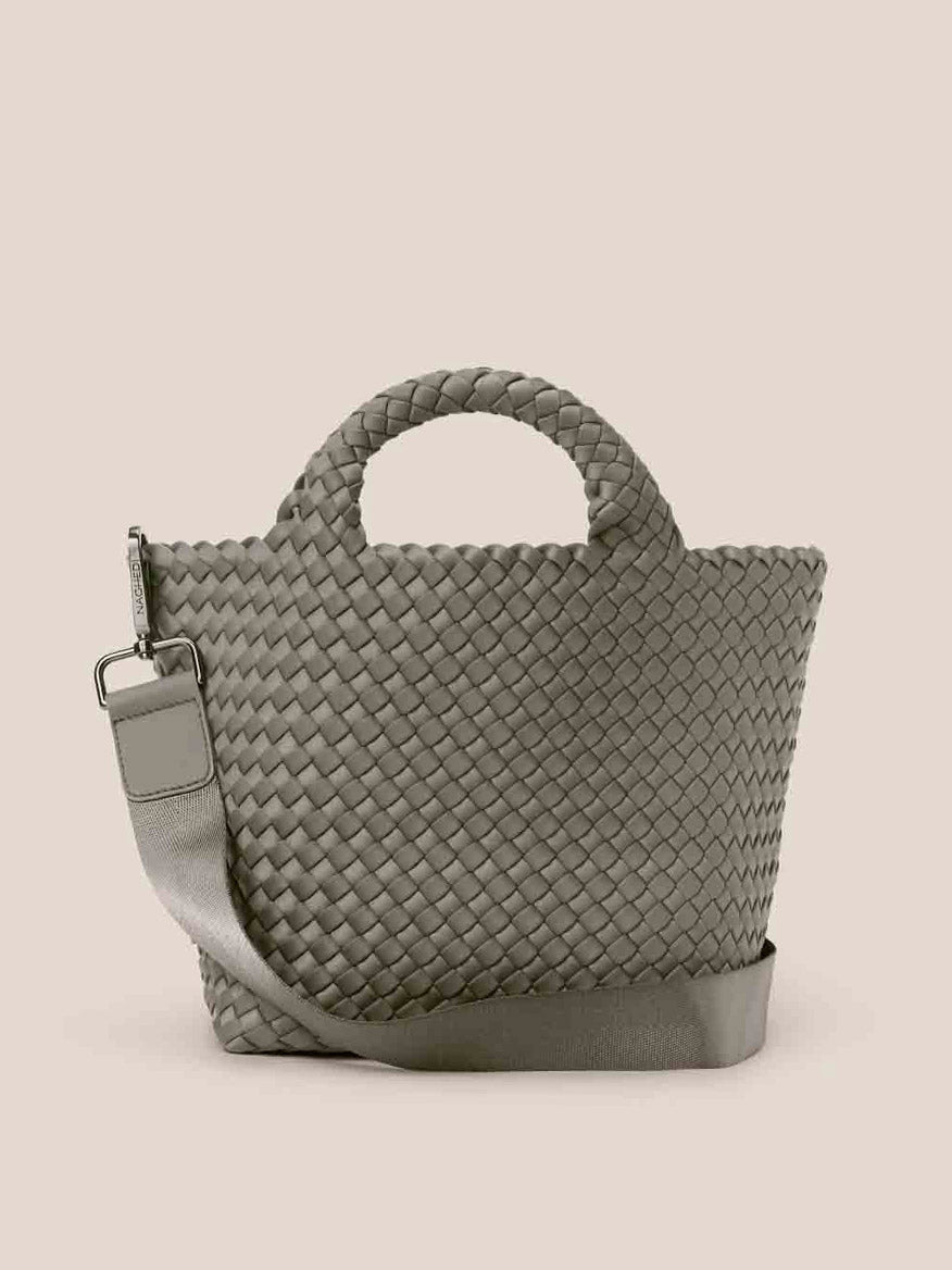 The Naghedi St. Barths Small Tote in Solid Laurel is a chic olive-green handbag crafted from handwoven neoprene, featuring short handles and an adjustable crossbody strap on a beige backdrop.