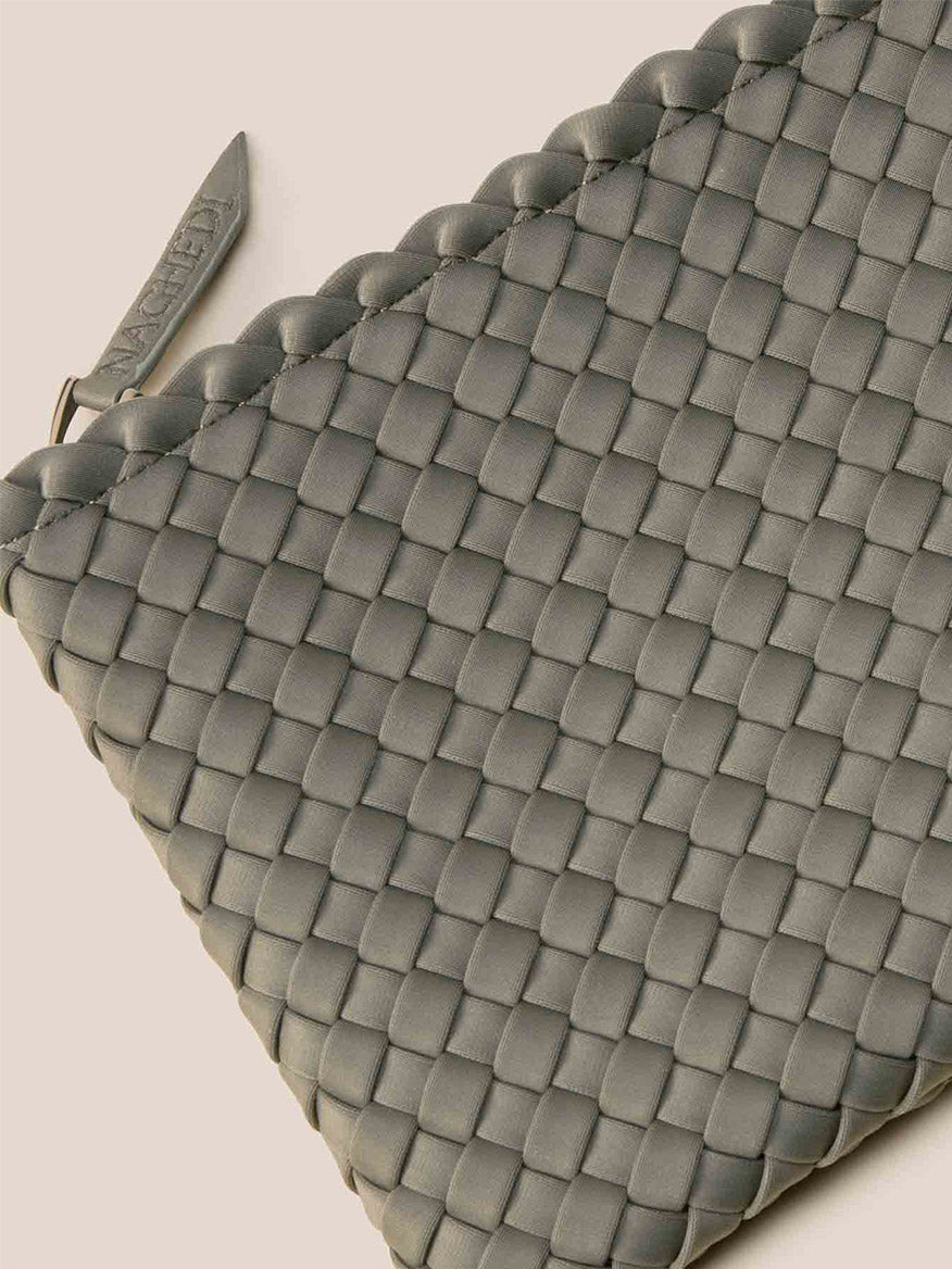 Naghedi St. Barths Small Tote in Solid Laurel, featuring a grey woven leather design with a zipper on a beige background and an adjustable crossbody strap for versatility.