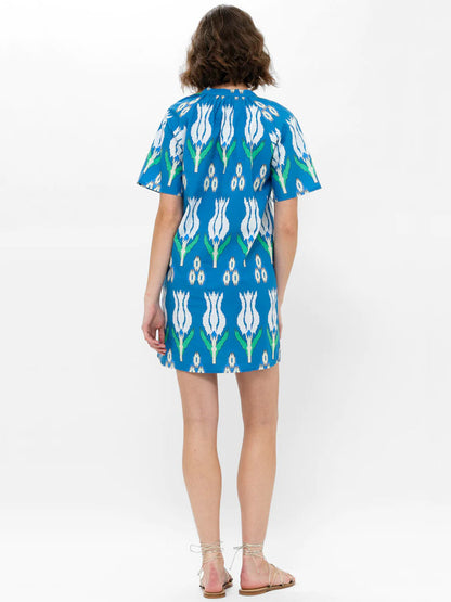 A woman wearing an Oliphant Pocket Dress in Sumba Blue Tulip standing with her back to the camera.