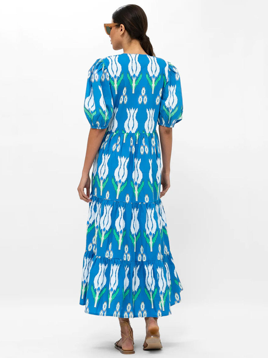Woman wearing an Oliphant Puff Sleeve Maxi Dress in Sumba Blue Tulip viewed from behind, designed with pockets.