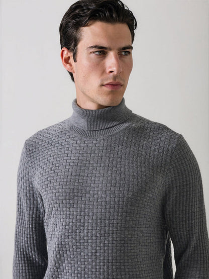A man with dark hair wears the Patrick Assaraf Extra-Fine Merino Wool Basketweave Turtleneck in Castlerock and looks to his left against a plain light background.