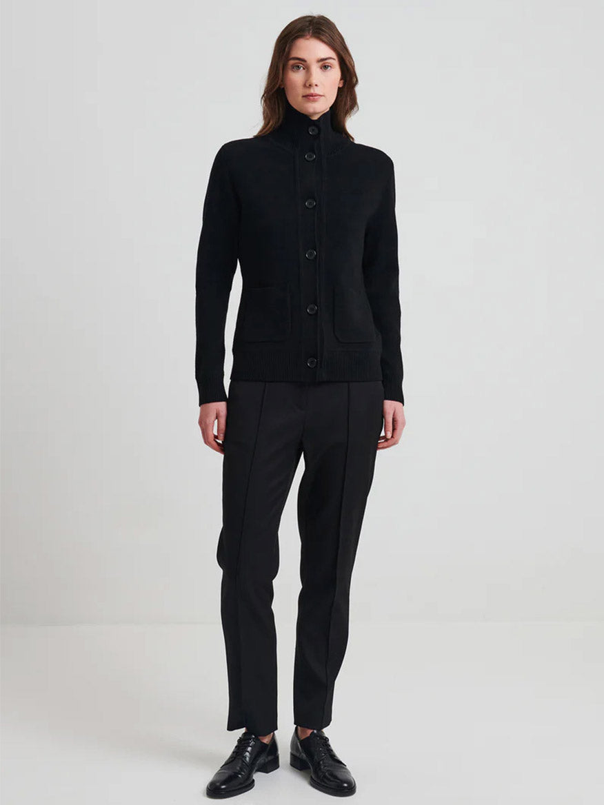 A person wearing the Patrick Assaraf Merino Button Front Milano Jacket in black, paired with matching black pants and shoes, stands against a plain background. The ensemble's layering is both stylish and refined.