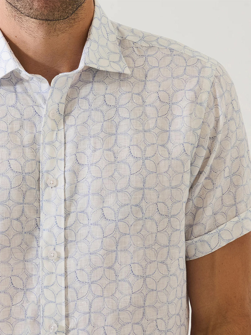 Man wearing the Patrick Assaraf Geometric Print Linen Shirt in Lake, a short sleeve pure linen shirt with a subtle blue geometric circle pattern, shown from shoulders to mid-arm.