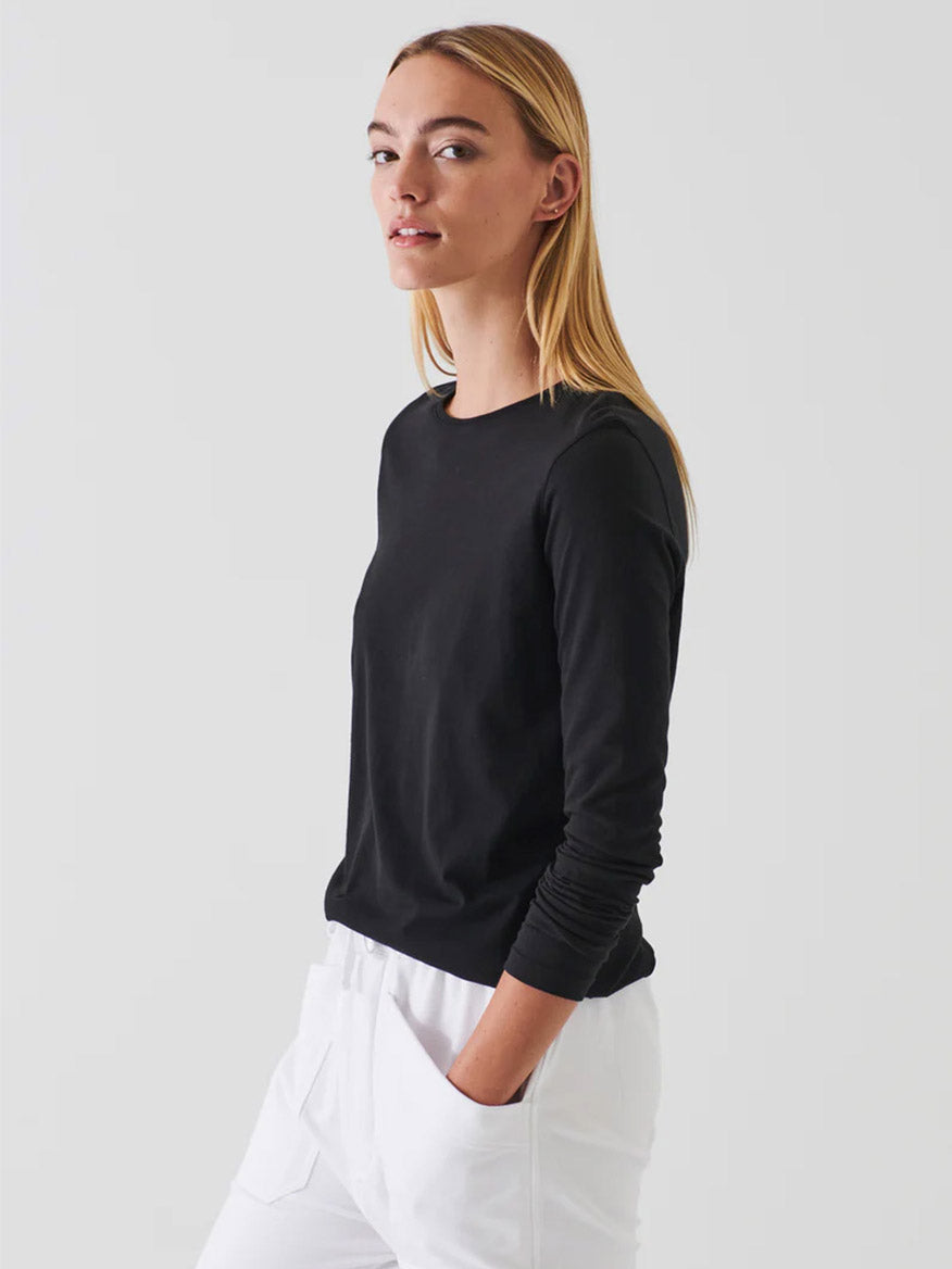 A woman in a classic fit, black long sleeve crewneck Patrick Assaraf Lightweight Pima Cotton T-Shirt.