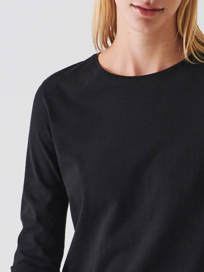 A close-up of a woman's neck adorned in a Patrick Assaraf Lightweight Pima Cotton T-Shirt in Black, featuring a soft, long sleeve crewneck design.