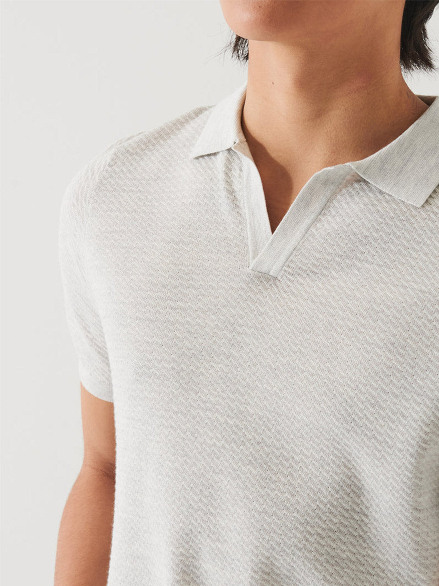 Close-up of a person wearing a Patrick Assaraf Cotton Cupro Open Polo in Drizzle, focusing on the collar and upper chest area.