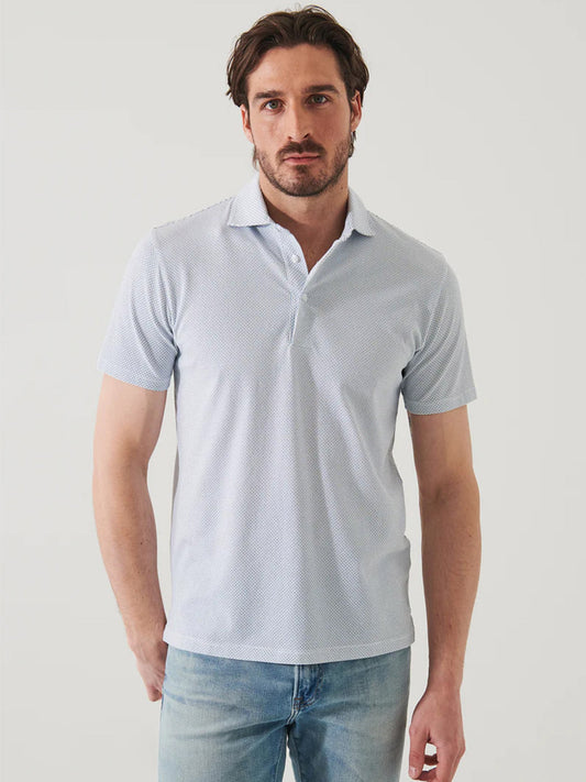 Man in a Patrick Assaraf Pima Cotton Stretch Printed Polo in New Oman Micro Diamond Dot short sleeve button polo shirt standing against a white background, looking at the camera.