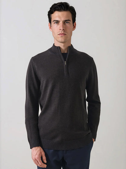 A man stands facing forward, wearing the Patrick Assaraf Merino Plaited Quarter Zip in Brownie and dark pants against a plain, light-colored background. The refined silhouette of his outfit offers lightweight warmth with understated style.