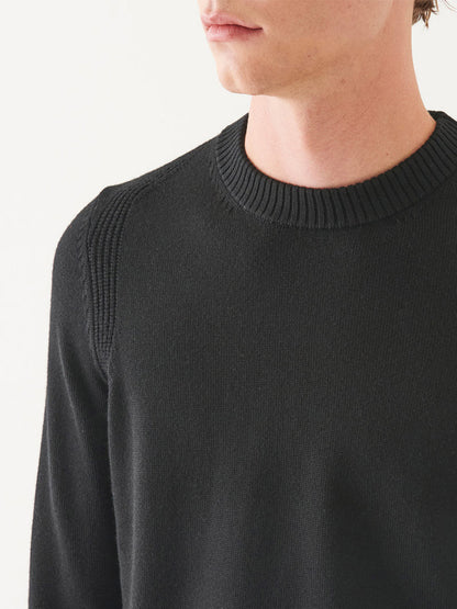 A person wearing the Patrick Assaraf Merino Crewneck in Black with a ribbed collar, perfect for enhancing your fall wardrobe.