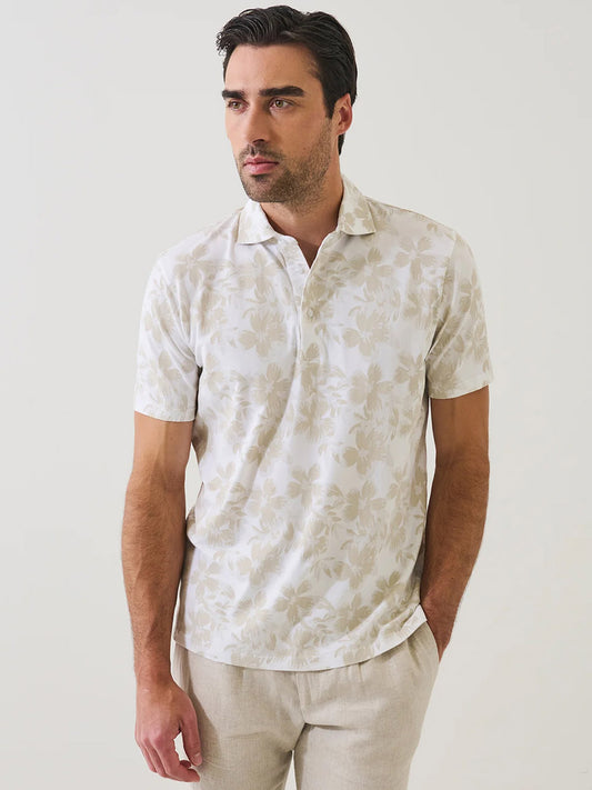 A man wears the Patrick Assaraf Pima Cotton Stretch Tropical Print Polo in Frappe and beige pants, standing against a plain white background.