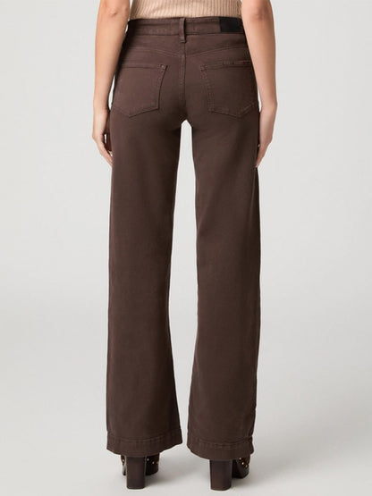 A person is wearing the Paige Leenah 32″ Wide Leg Jean in Rich Chocolate with a beige top, standing with their back to the camera against a plain light background.