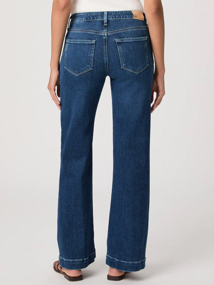 A person wearing Paige Leenah 32" Wide Leg Jean in Venetian Breeze and sandals, shown from the back against a plain background.