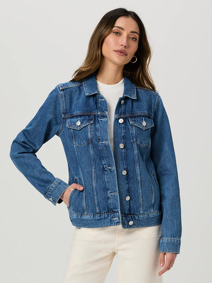 A woman wearing the Paige Rowan Jacket in Bellisimo over a white shirt and cream-colored pants stands with one hand in her pocket, showcasing a vintage style against a plain background.